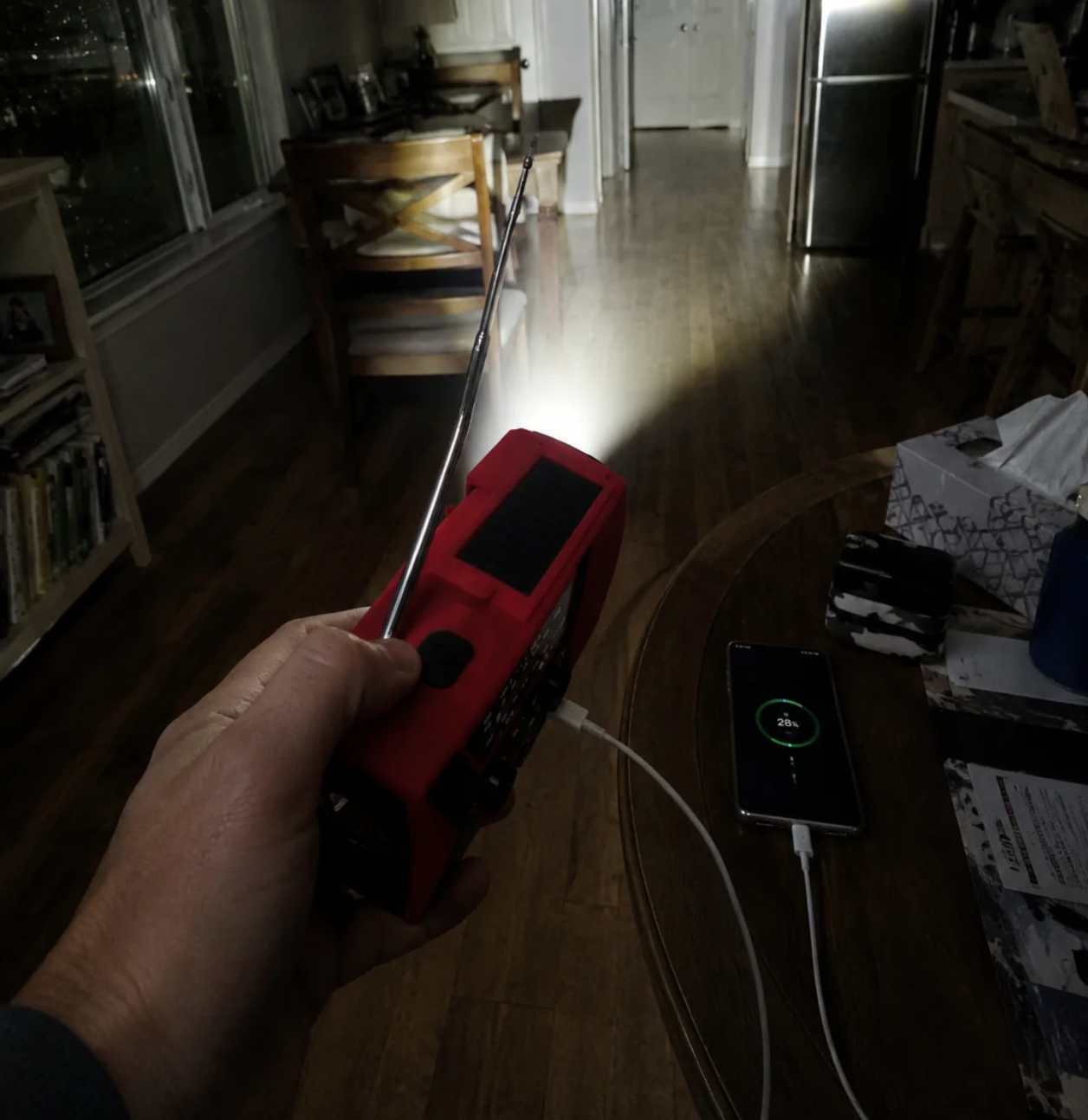 Das VeloStep Rettungsradio in einer Hand, Antenne ausgezogen, Taschenlampe an